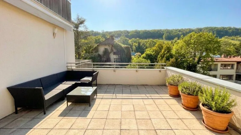 Geräumige Sonnenterrasse mit bequemer Lounge-Sitzgruppe und weitem Blick ins Grüne.