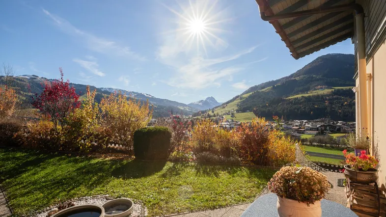 Sonnige Terrasse mit Panoramablick auf die umliegende Berglandschaft und das Tal.