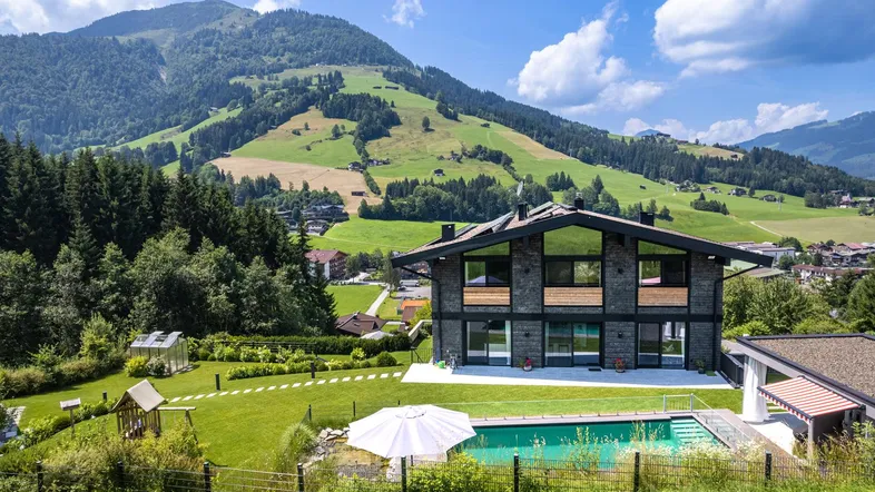 Großzügiges Anwesen mit modernem Haus, weitläufigem Garten, Pool und Bergblick.