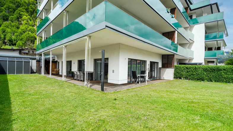 Moderne Wohnanlage mit großzügiger Terrasse und direktem Zugang zum gepflegten Rasenbereich.