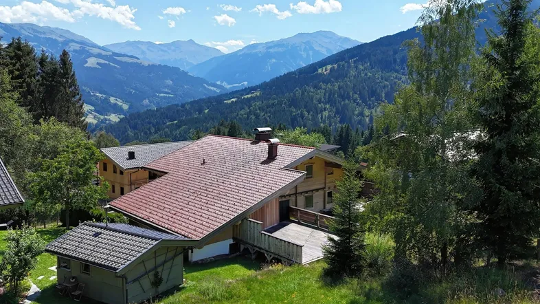 Charmantes Holzhaus in alpiner Landschaft mit beeindruckendem Bergblick und grüner Umgebung.