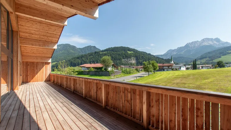 Geräumiger Holzbalkon mit atemberaubendem Bergblick und Aussicht auf die umliegende Landschaft.