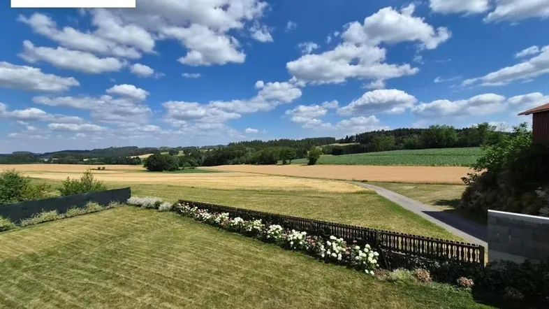Weitläufiger Gartenbereich mit gepflegtem Rasen und malerischem Blick auf die umliegende Landschaft.