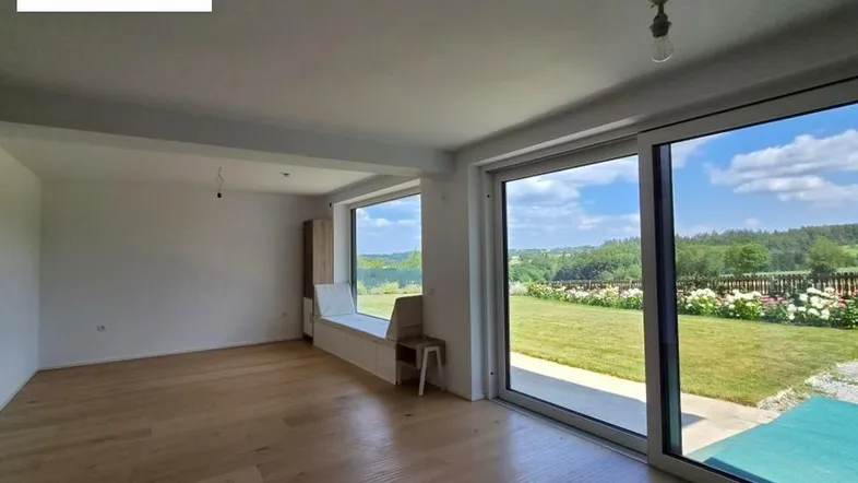Helles Zimmer mit großen Schiebetüren, Holzboden und weitem Blick ins Grüne.