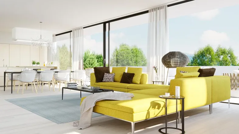 Helles, offenes Wohnzimmer mit moderner Einrichtung, großen Fenstern und integriertem Essbereich.