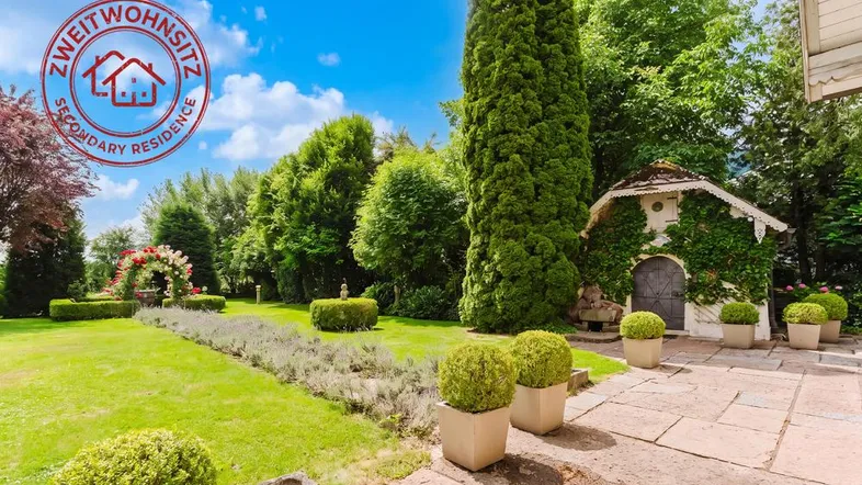 Gepflegter Garten mit Lavendelpfad, Ziersträuchern und einem charmanten Gartenhaus.