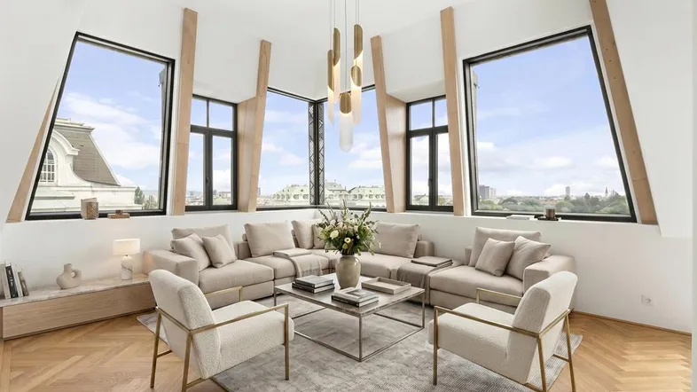 Helles, modern eingerichtetes Wohnzimmer mit großen Fenstern, Stadtblick und elegantem Fischgrätparkett.