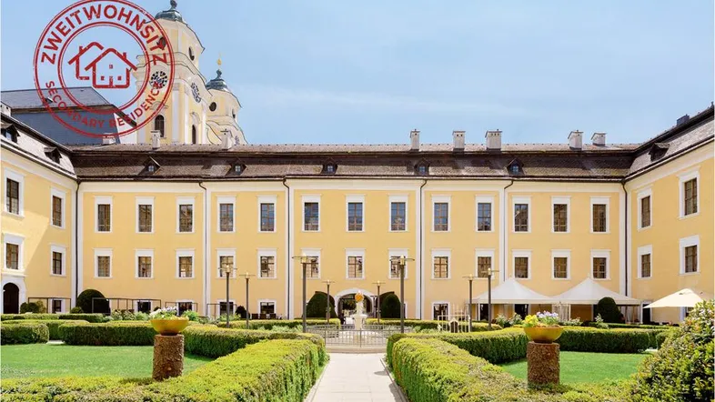 Prächtiger Innenhof mit gepflegtem Gartenbereich und historischer Architektur des Gebäudes.