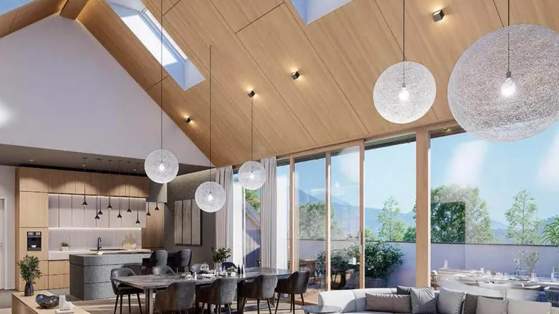 Modernes, offenes Wohn-Esszimmer mit Holzdachschrägen, großen Fenstern und Bergblick.