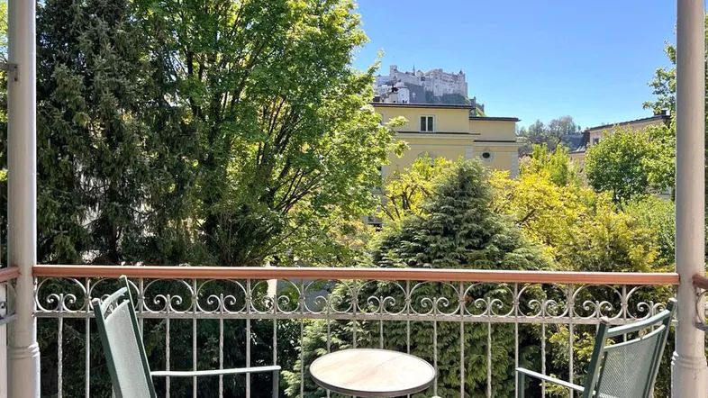 Balkon mit Sitzgelegenheiten und malerischem Blick auf die Festung Hohensalzburg.