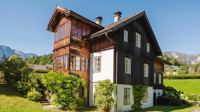 Traditionelles Chalet mit aufwendigen Holzschnitzereien, Balkon und Bergblick in sonniger Lage.
