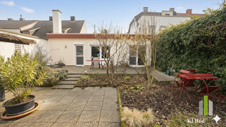 Terrasse mit Gartenbereich hinter dem Haus, umgeben von Grün und mit Sitzgelegenheiten.
