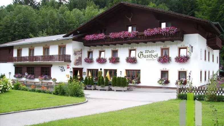Traditionelles Gasthaus mit Blumenkästen und gepflegtem Vorgarten in ländlicher Umgebung.