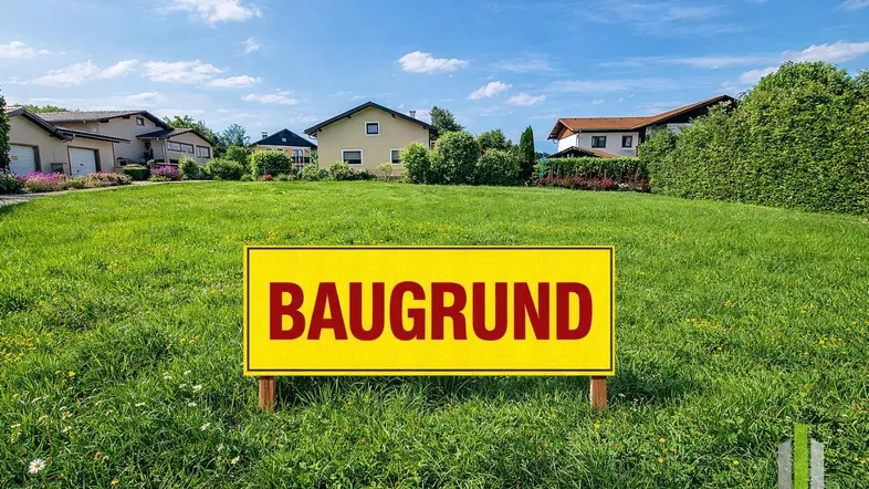 Baugrundstück in ländlicher Umgebung mit umliegenden Häusern und viel Grünfläche unter blauem Himmel.