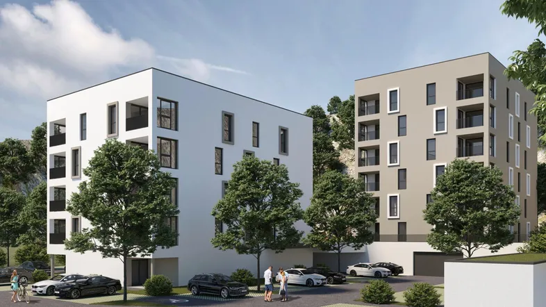 Moderne Wohngebäude mit klarer Architektur, umgeben von Grünflächen und Parkplätzen.