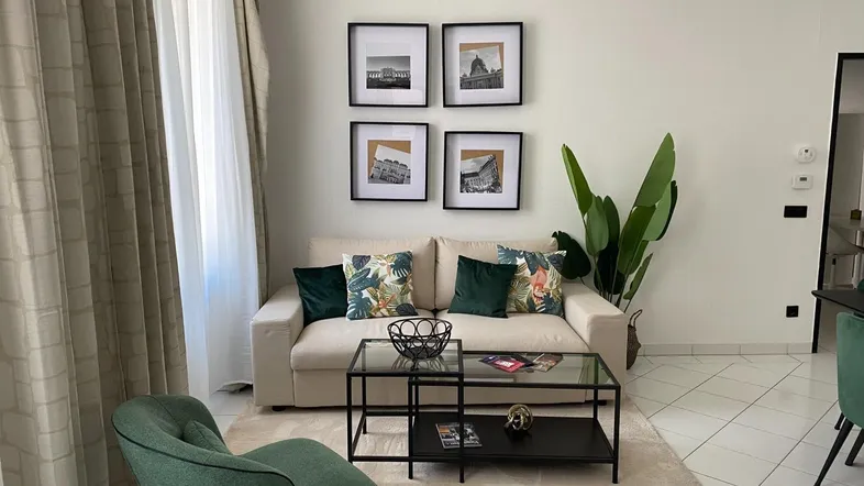 Helles Wohnzimmer mit beigem Sofa, modernem Couchtisch und dekorativen Bildern an der Wand.