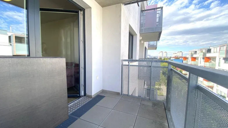 Geräumiger Balkon mit Fliesenboden und Blick auf die umliegenden Gebäude.