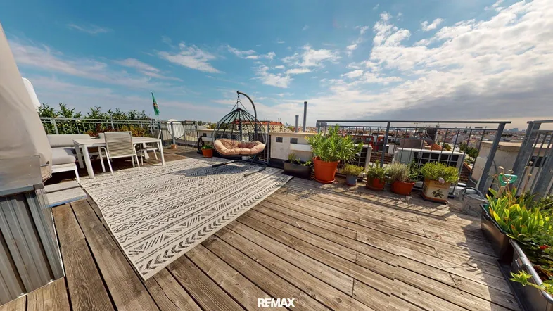 Geräumige Dachterrasse mit Holzboden, Sitzgelegenheiten und Pflanzen, ideal zum Entspannen.