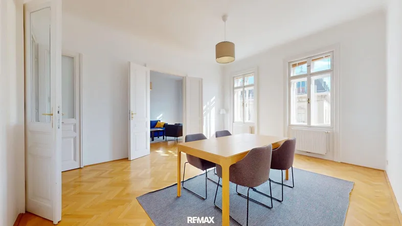 Heller Essbereich mit Holztisch, modernen Stühlen und Blick in ein weiteres Zimmer.