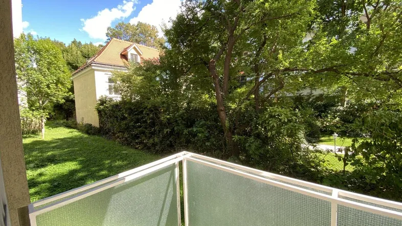 Balkon mit Blick ins Grüne und auf ein charmantes Nachbargebäude.