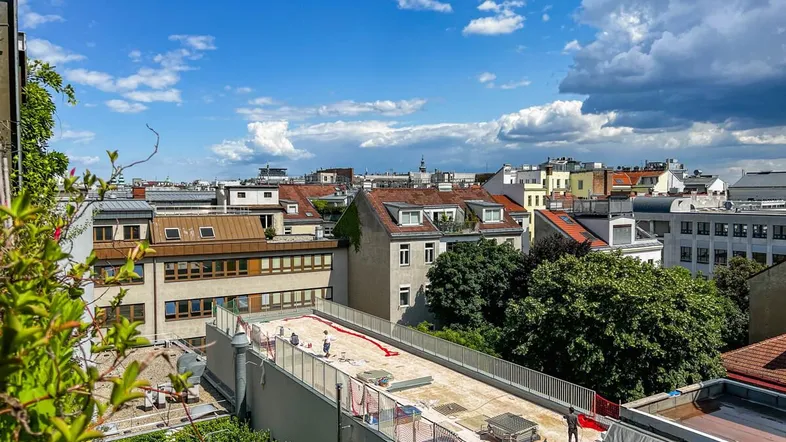 Panoramablick über die Dächer der Stadt an einem sonnigen Tag mit blauem Himmel und Wolken.
