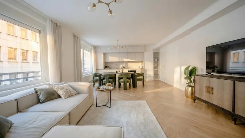 Helles, offenes Wohn- und Esszimmer mit moderner Küche und elegantem Parkettboden.