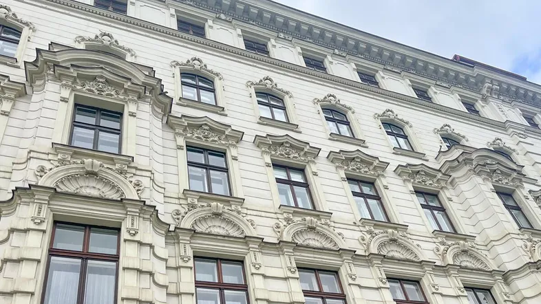 Eindrucksvolle historische Fassade eines Altbaus mit reich verzierten Fenstern und Details.