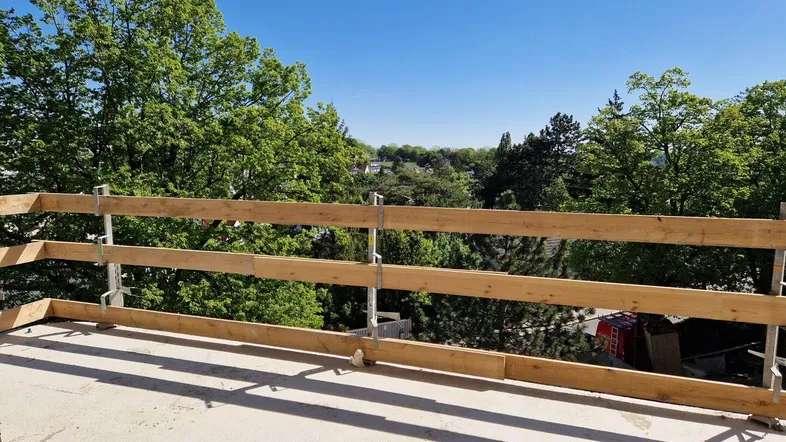 Im Bau befindliche Terrasse mit weitem Blick über Bäume und die umliegende Wohnbebauung.