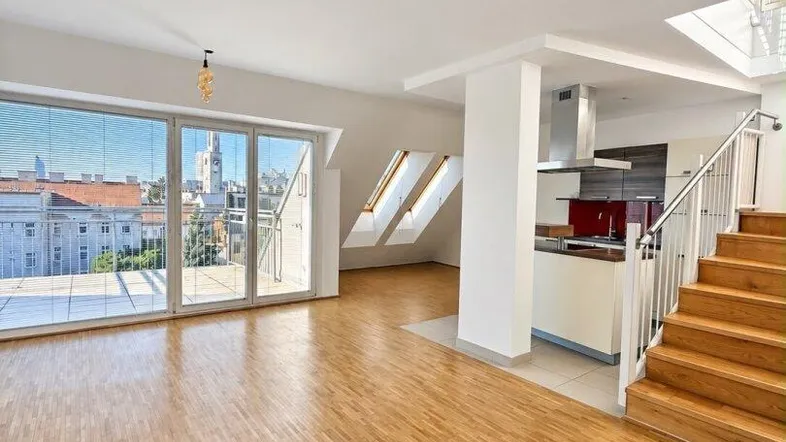 Heller, offener Wohn- und Essbereich mit Holzboden, moderner Küche und Zugang zur Dachterrasse.