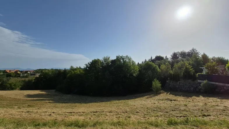 Sonniges Grundstück mit weitem Blick über die Landschaft und umgebende Natur.