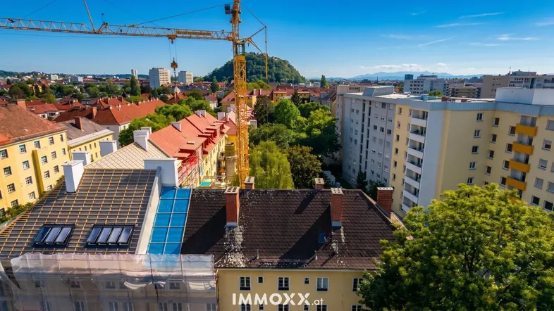 Luftaufnahme einer städtischen Umgebung mit Wohngebäuden, einem Baukran und Solaranlagen auf Dächern.