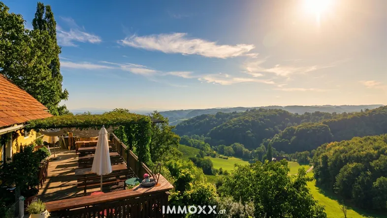 Große Holzterrasse mit Sitzgelegenheiten und weitem Blick über die malerische Weinlandschaft.