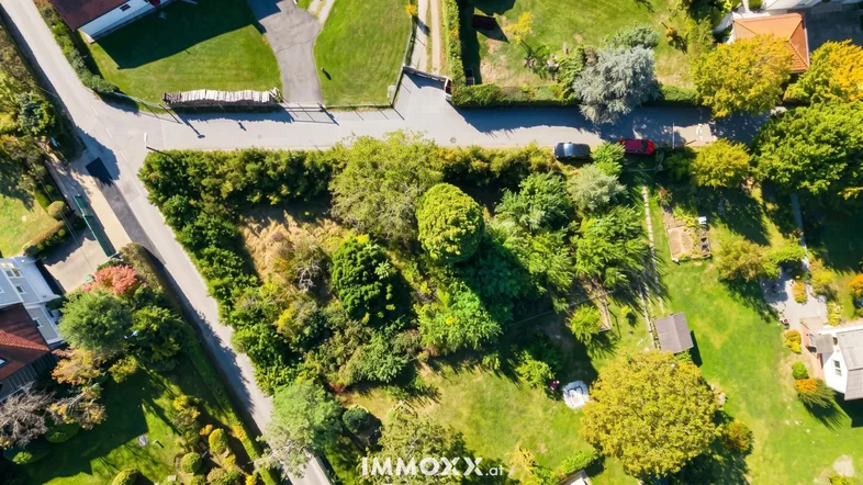 Luftaufnahme eines grünen Grundstücks mit umliegenden Straßen und Häusern in ländlicher Umgebung.