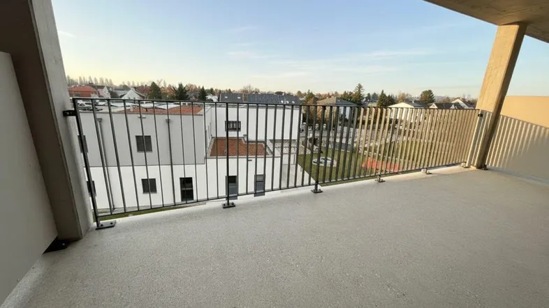Geräumiger Balkon mit Blick auf die umliegende Wohnsiedlung und den Himmel.