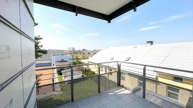 Heller Balkon mit Fliesenboden und Metallgeländer, bietet einen weiten Blick über die Umgebung.