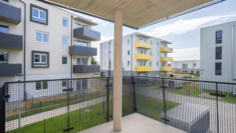 Balkon mit Blick auf die umliegenden Neubauten und den begrünten Innenhof.