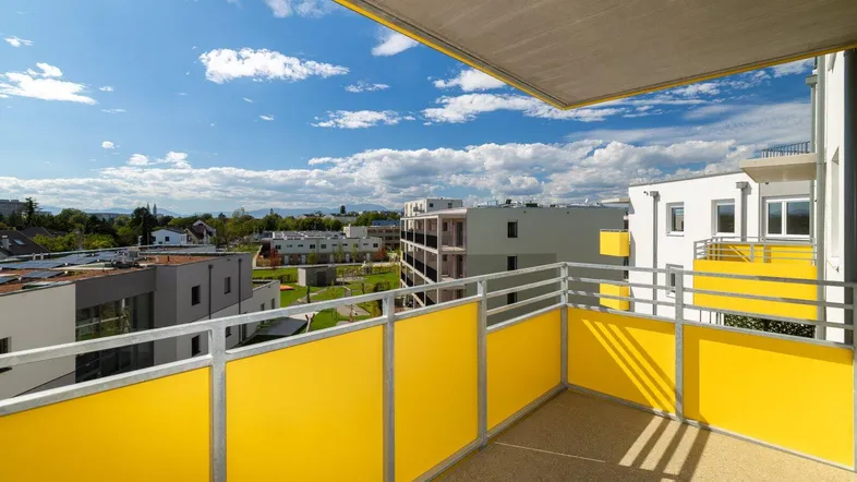 Geräumiger Balkon mit gelben Sichtschutzelementen und weitem Blick über die Umgebung.