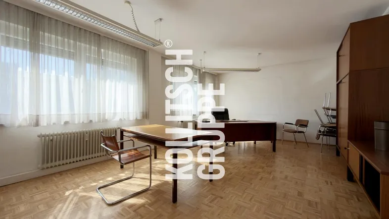 Geräumiges Büro mit Parkettboden, großen Fenstern und funktionaler Einrichtung.