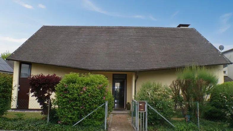 Vorderansicht eines Einfamilienhauses mit Satteldach und gepflegtem Vorgarten.