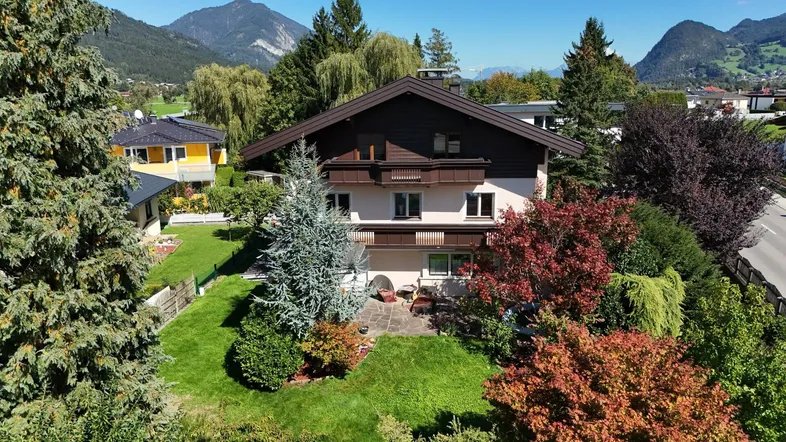 Luftaufnahme des Hauses mit gepflegtem Garten und Bergblick in sonniger Umgebung.