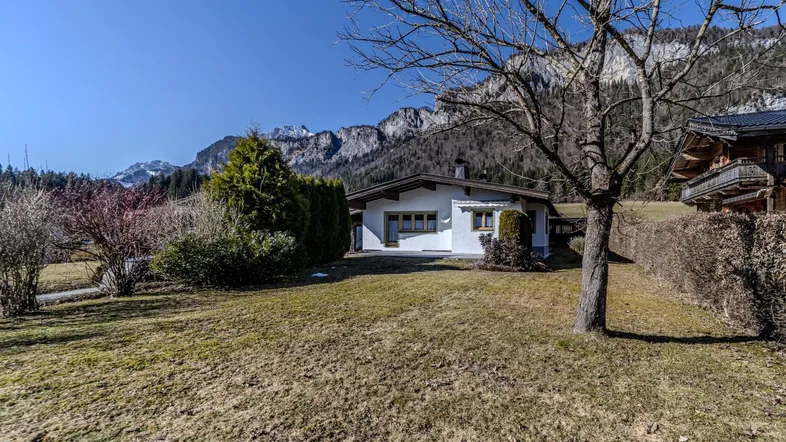 Großzügiger Gartenbereich vor dem Haus mit weitem Blick auf die umliegende Berglandschaft.