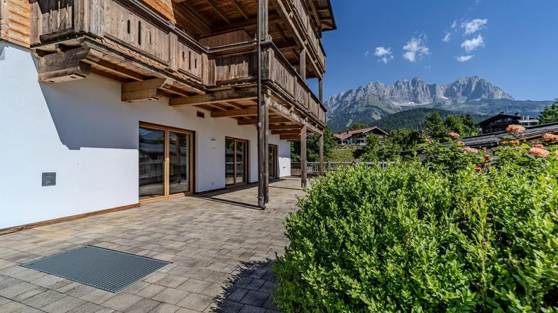 Geräumige gepflasterte Terrasse mit Blick auf die Berge und üppiges Grün.