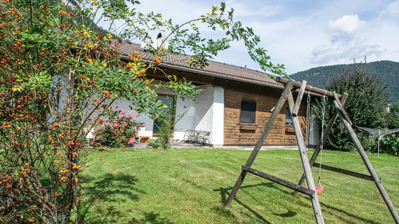 Großer Garten mit Schaukel und Blick auf die umliegenden Berge, ideal für Familien.