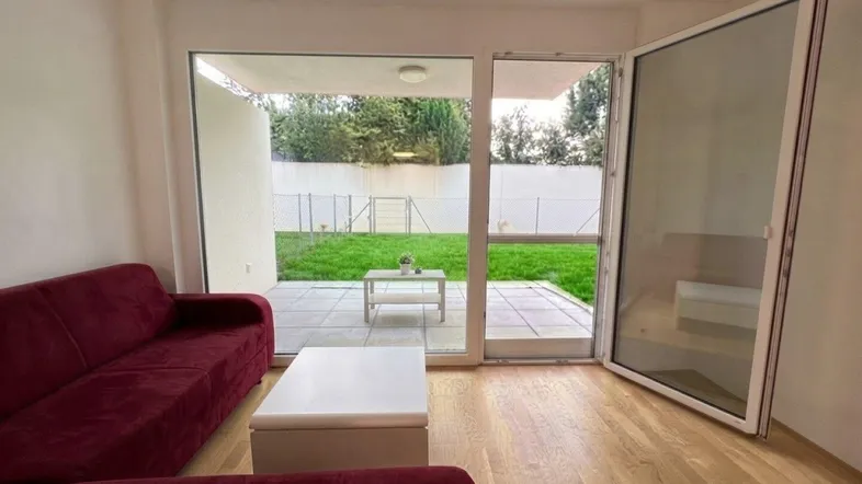 Helles Wohnzimmer mit Holzboden und direktem Zugang zur Terrasse und zum Garten.