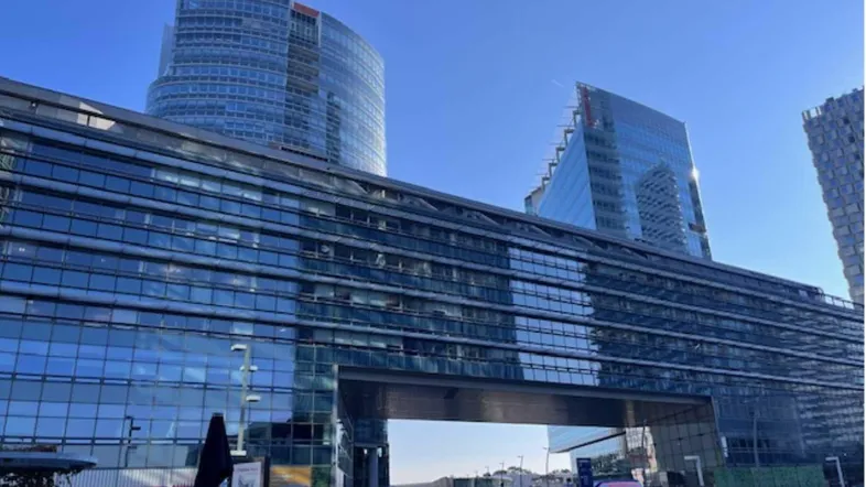 Moderne Bürogebäude mit Glasfassaden und einem Durchgang, die eine städtische Umgebung prägen.