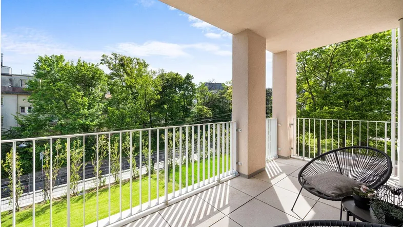 Geräumiger Balkon mit modernen Sitzgelegenheiten und Blick ins Grüne, ideal zum Entspannen.