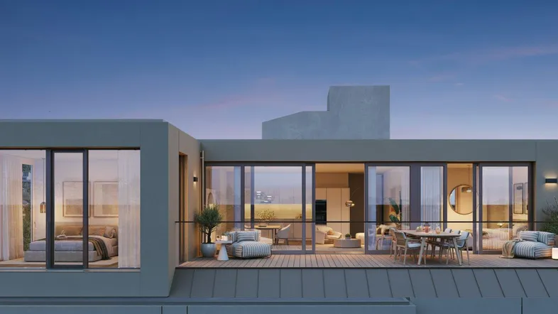 Moderne Dachterrasse mit stilvollen Outdoor-Möbeln und Blick in helle Innenräume bei Abenddämmerung.