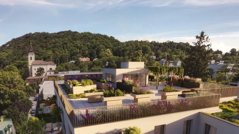 Moderne Wohnanlage mit begrünten Dachterrassen und Blick auf die umliegende Hügellandschaft.