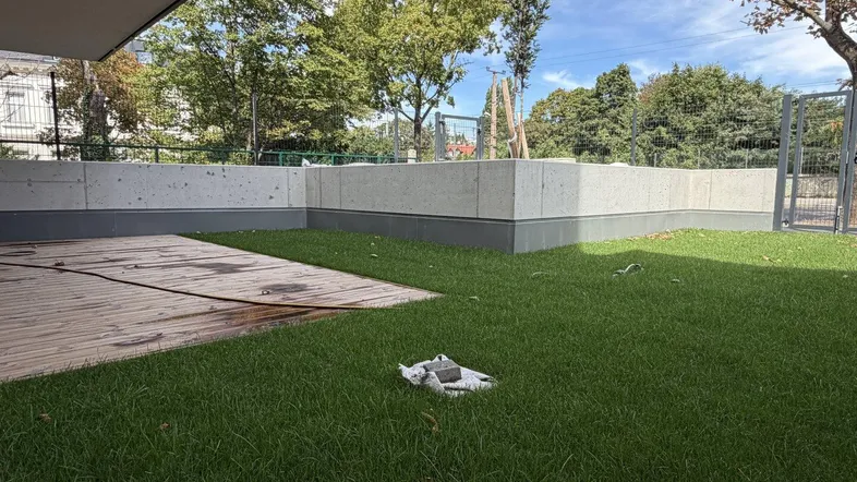Gepflegter Gartenbereich mit Rasenfläche und Holzterrasse, ideal für Entspannung im Freien.
