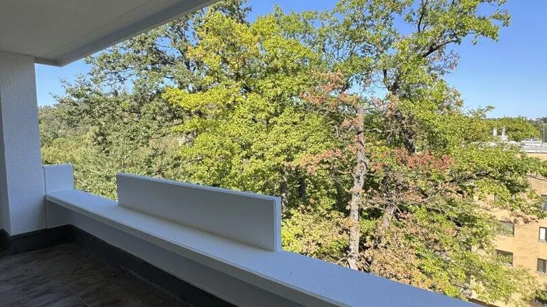 Geräumiger Balkon mit Fliesenboden und weitem Blick ins Grüne und auf die Umgebung.